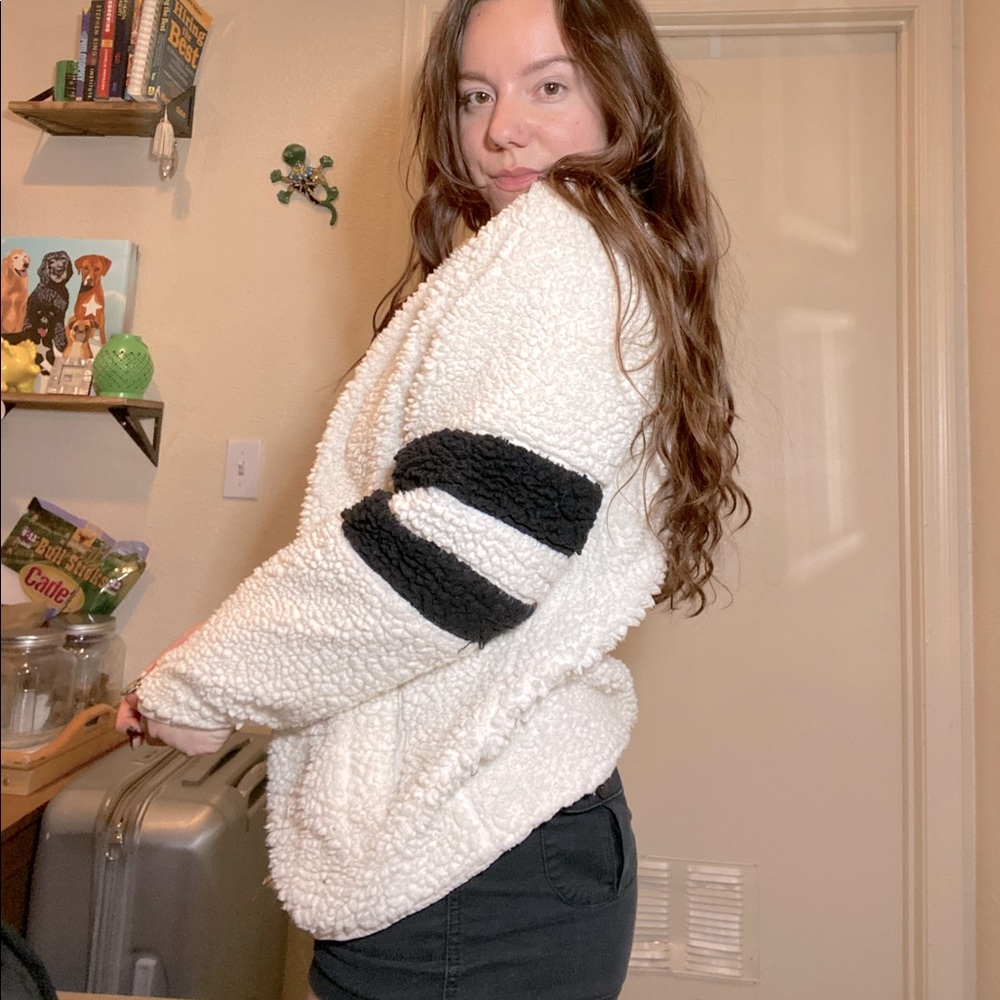 White fuzzy sweater with black striped sleeves
